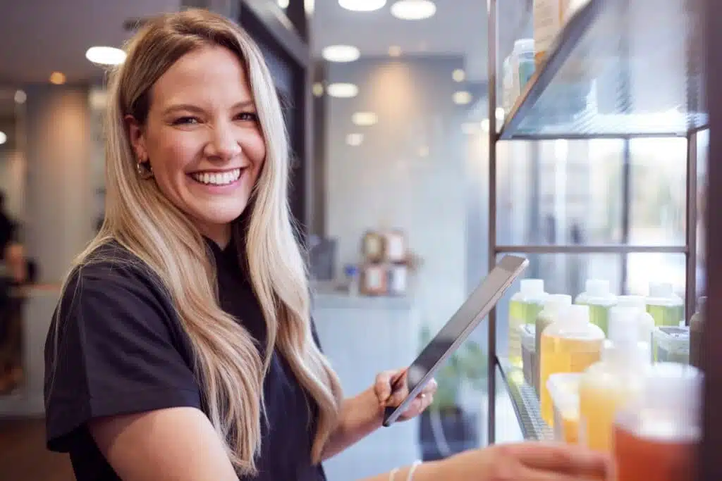 Woman in beauty salon holding a tablet.