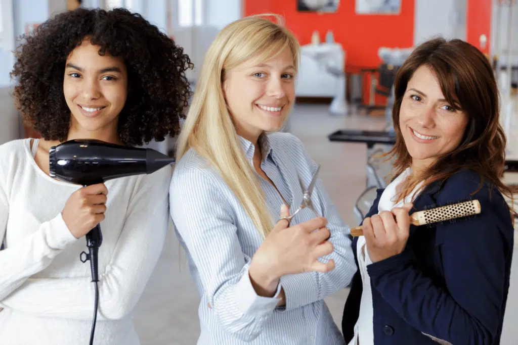 air salon behind the scene women staff holding hair dryer, scissors and brush