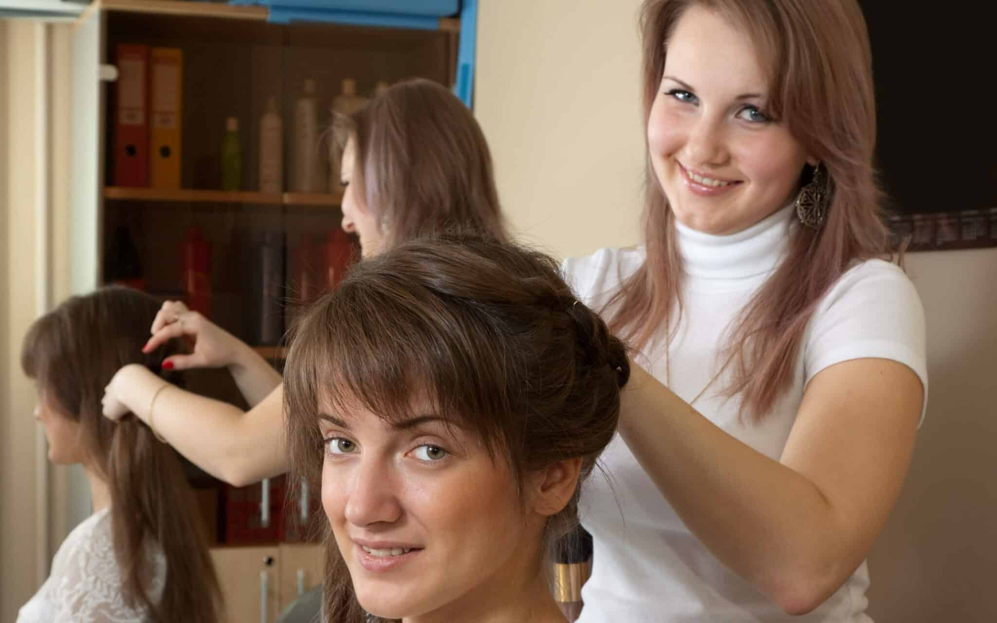 two hairdressers smiling to the camera