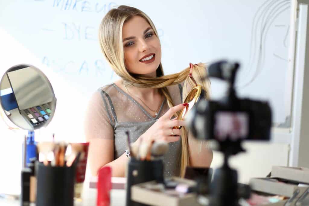 woman brushing hair making a video with camera for social media 3