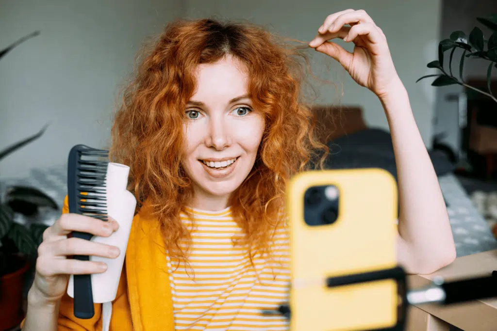 ginger woman making video about hair care at home