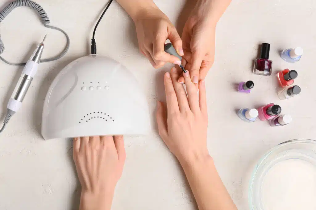 nail salon equipment being used by a nail professional on clients' hands