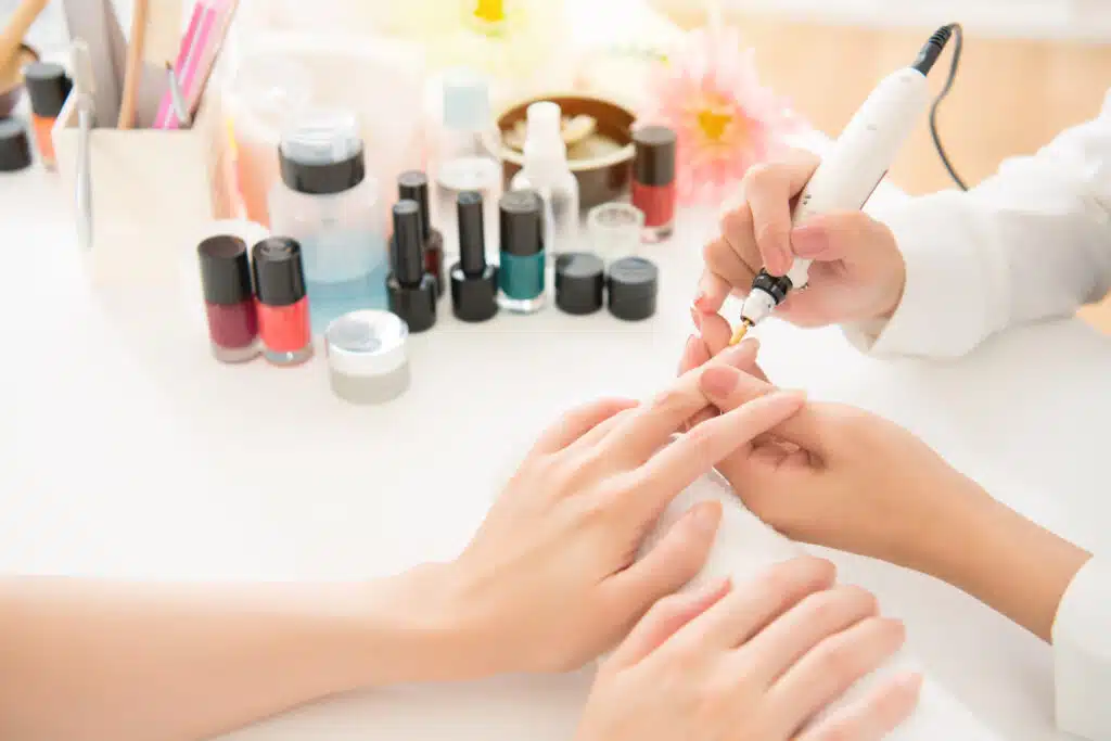 nail salon professional serving client with proper equipment and materials