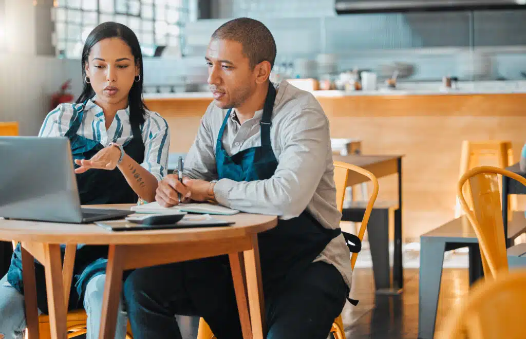 small business partners setting long term goals for their business with cafe on the backdrop