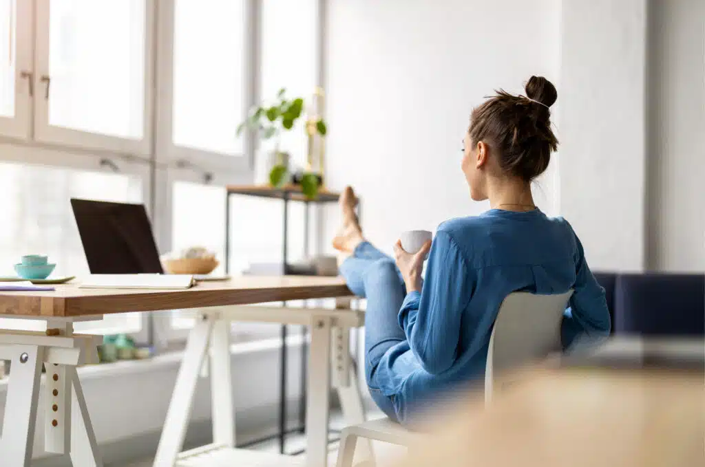 business woman relaxing during work with feet up and laptop open turned off