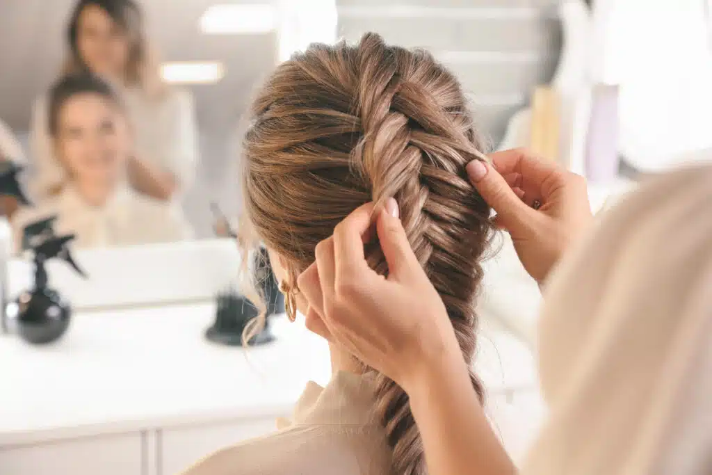 hairdresser working with classy hairstyle on client in beauty salon