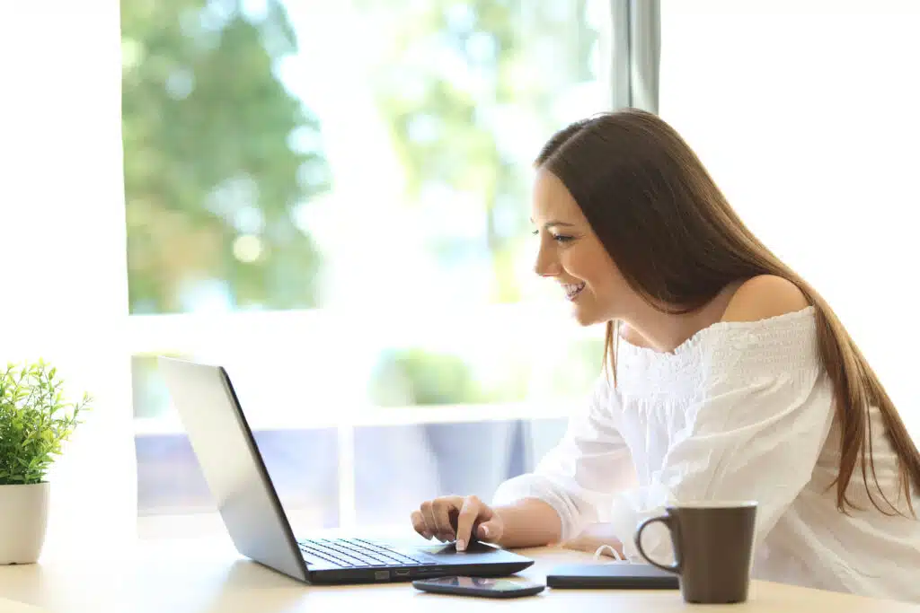 woman opening laptop and smiling