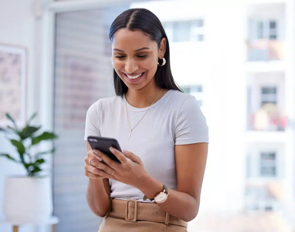 female client receiving text message and checking her phone while smiling