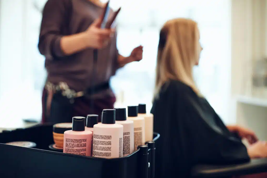 hair salon products inside of a box with hairdresser and client in the background