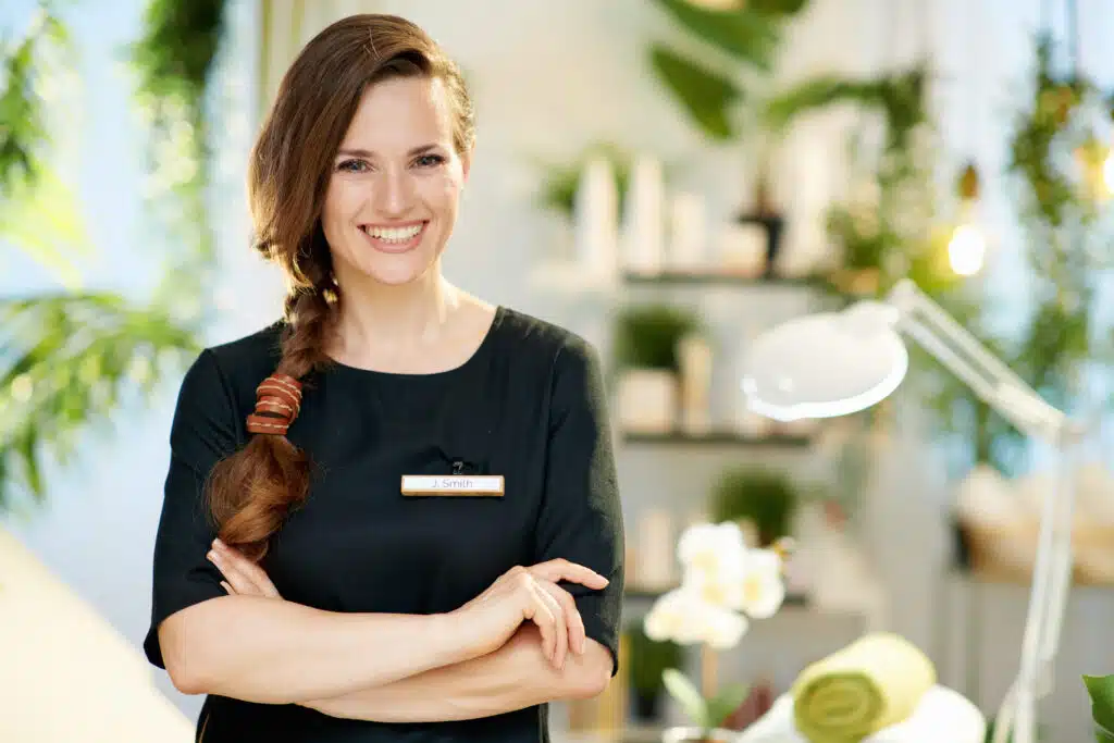 spa business owner woman in black with plants in the background